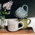 Three mugs on a wooden surface with a dark background