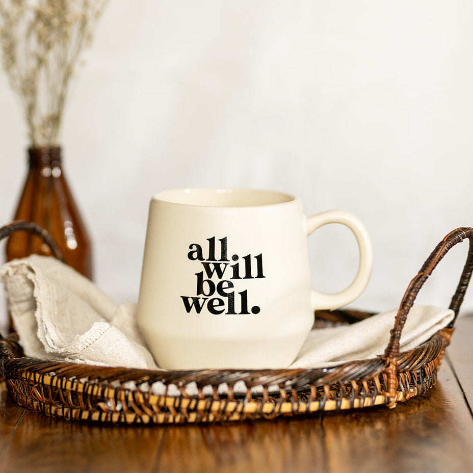A cream-colored ceramic mug with the text &