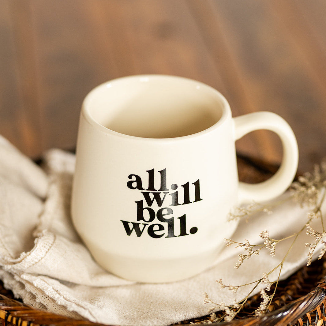 A cream-colored ceramic mug with the phrase &