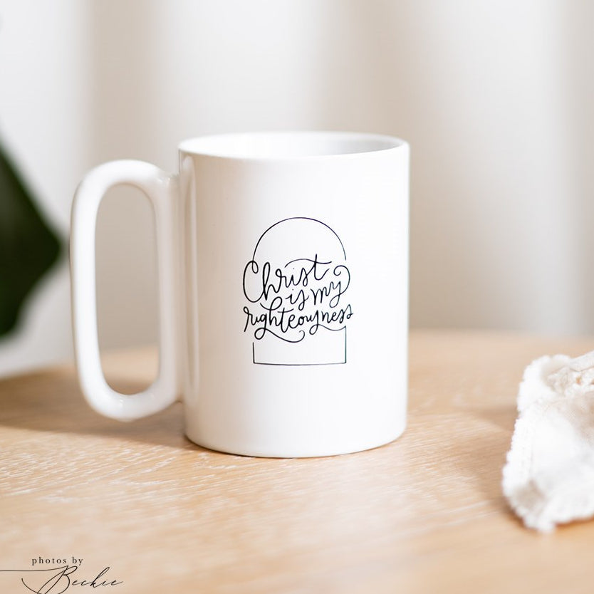 A white ceramic coffee mug with black hand-lettered text reading &