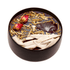 Black container with dried herbs and flowers on a white background