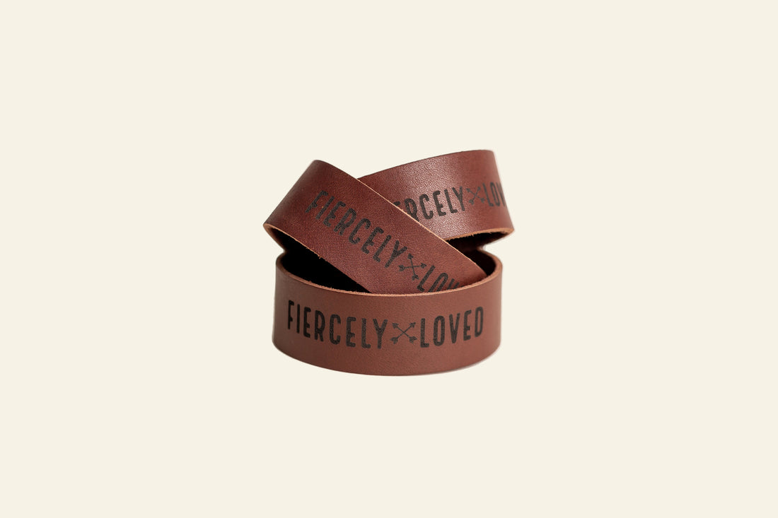 Two brown wristbands with &