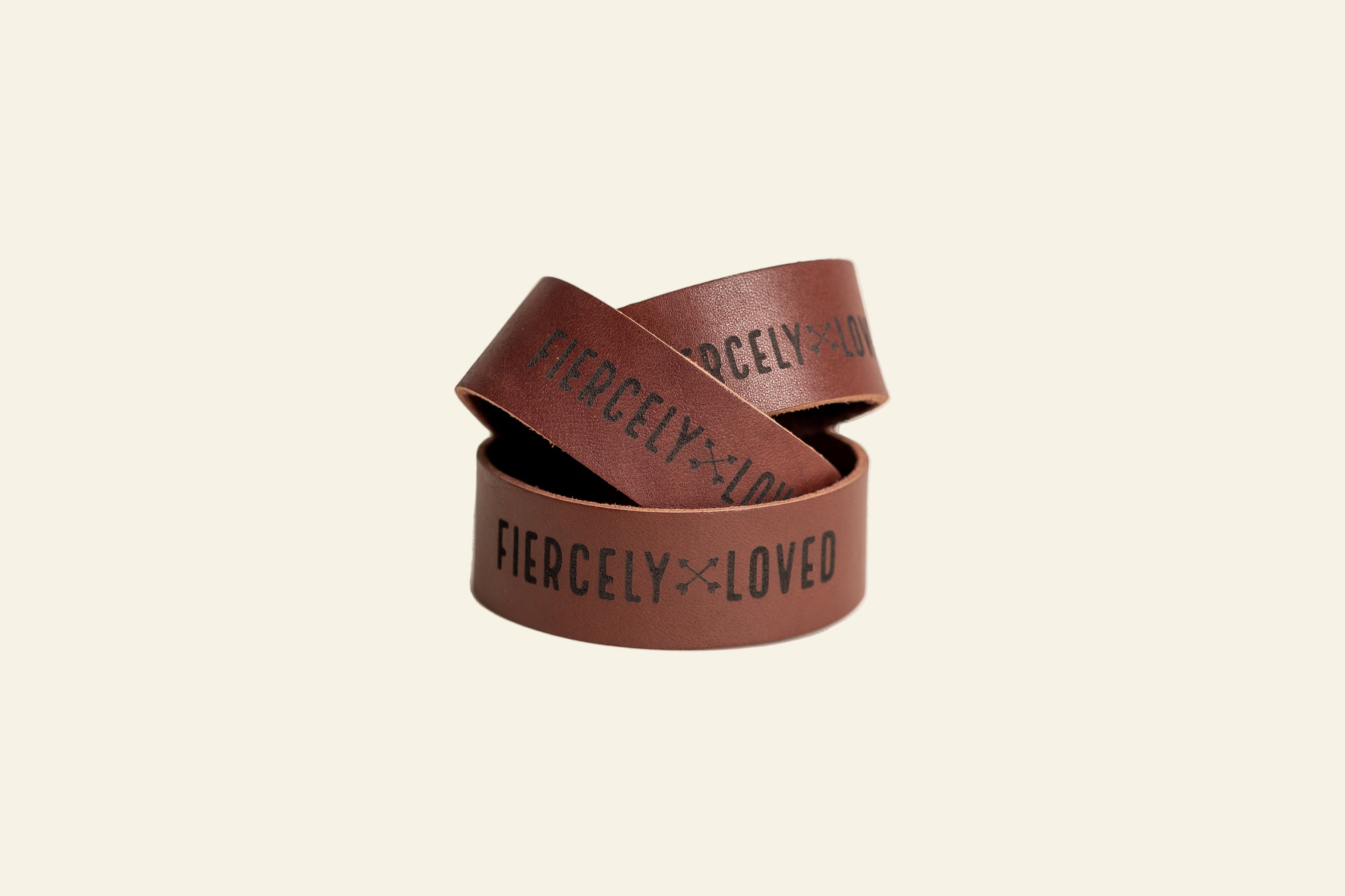 Two brown wristbands with &