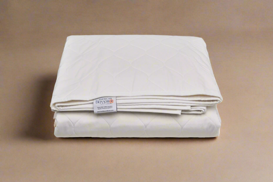 Folded white quilt with a label on a brown background