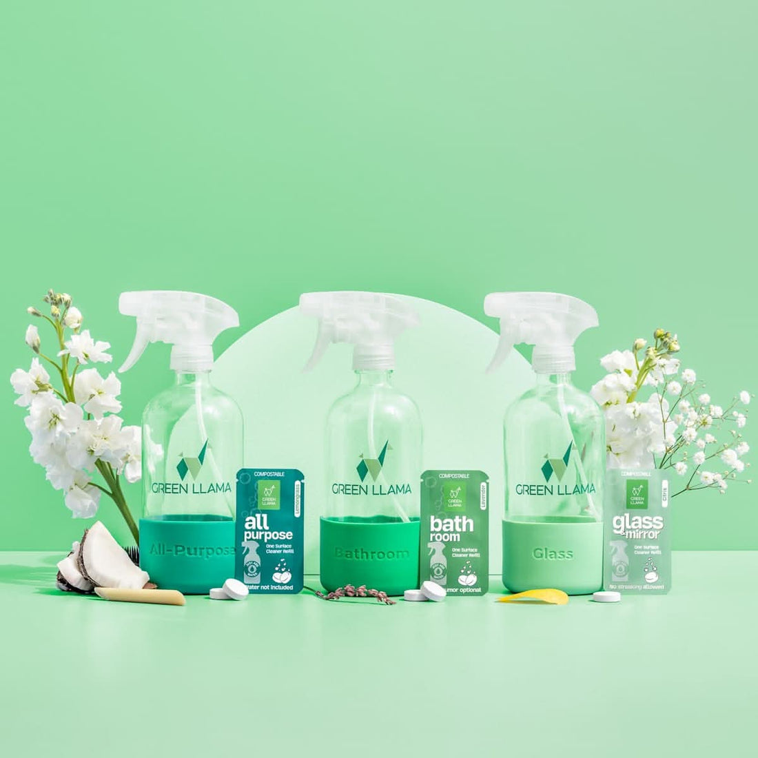 Set of Green Llama cleaning products on a green background with white flowers.