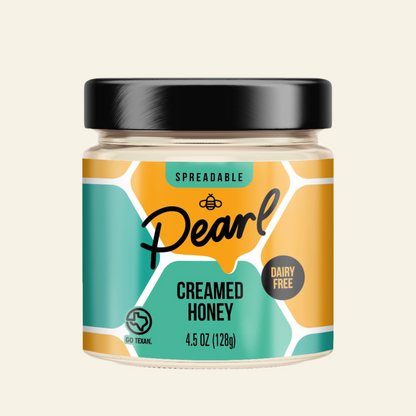 Jar of Pearl Creamed Honey with a black lid on a white background