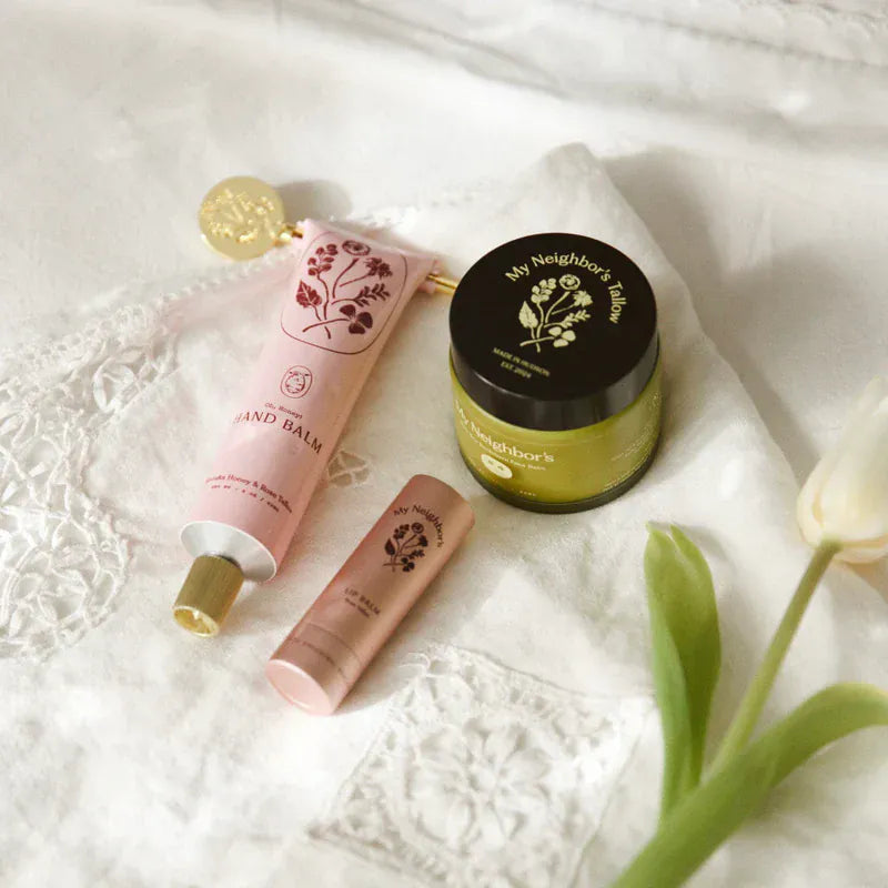 Hand balm and jar on a textured surface with a tulip flower.