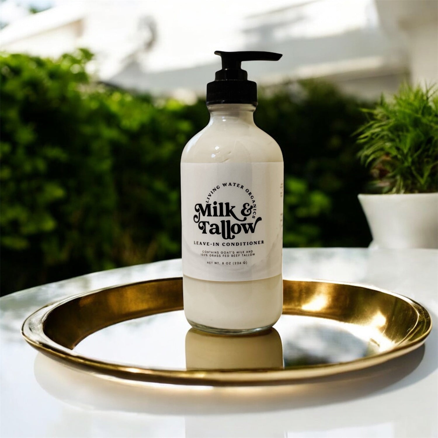 Bottle of Milk &amp; Fallow conditioner on a gold tray with a blurred outdoor background