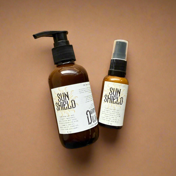 Two bottles of Sun Shield on a brown background
