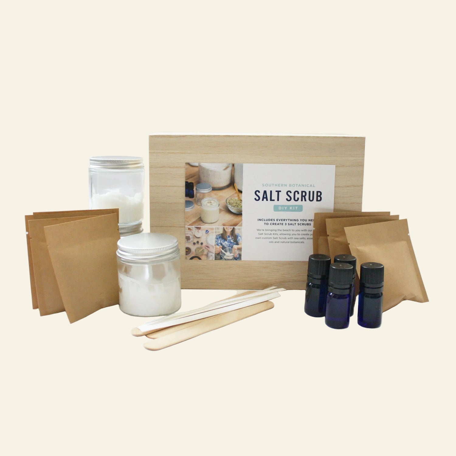 Salt scrub kit with jars, sticks, and bottles on a white background