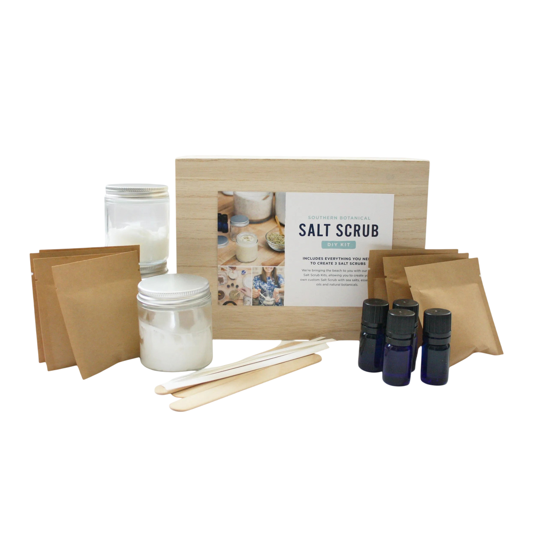 Salt scrub kit with jars, sticks, and bottles on a white background