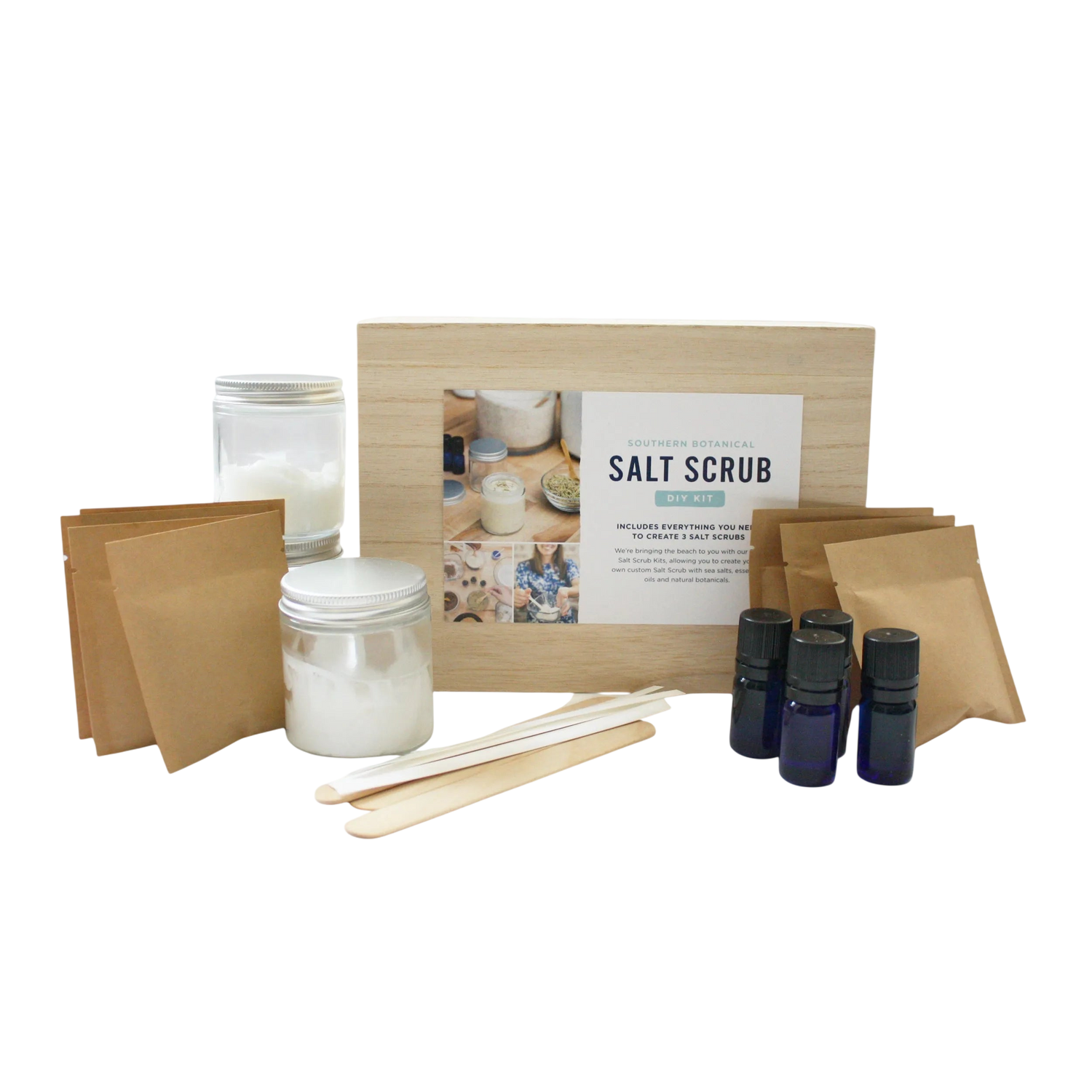 Salt scrub kit with jars, sticks, and bottles on a white background