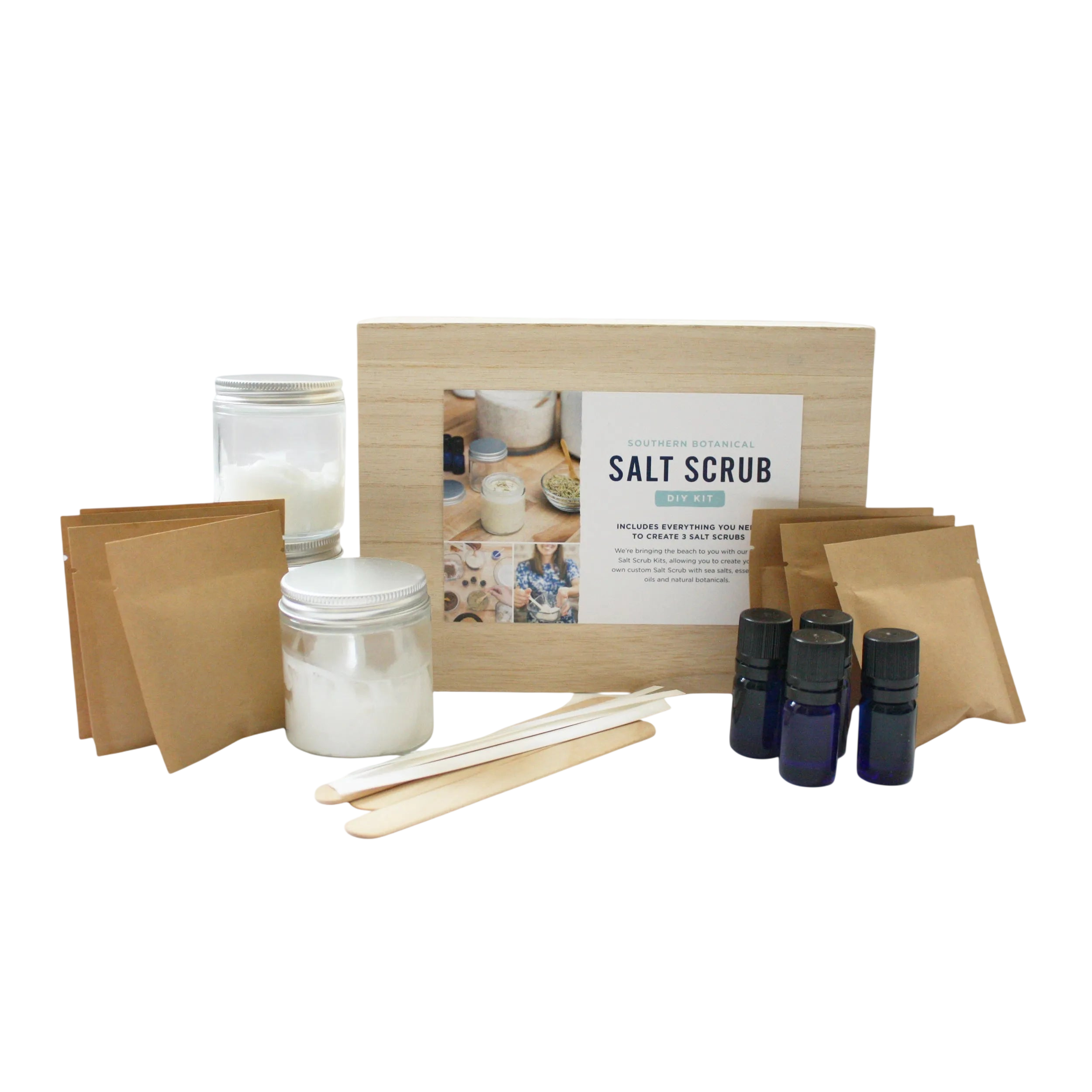 Salt scrub kit with jars, sticks, and bottles on a white background