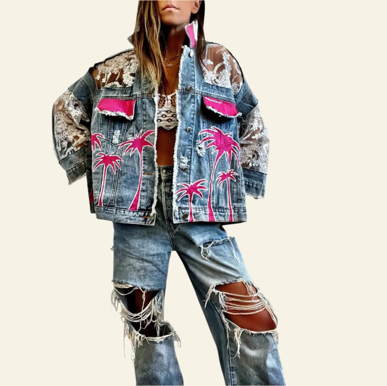 Person wearing a denim jacket with pink palm tree designs and ripped jeans on a white background