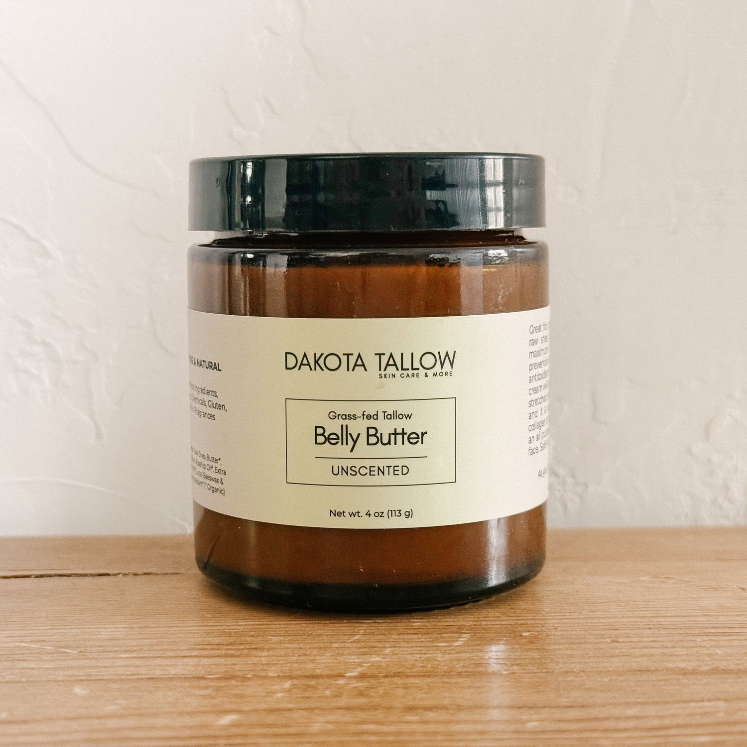 Jar of Dakota Tallow Belly Butter on a wooden surface with a white background