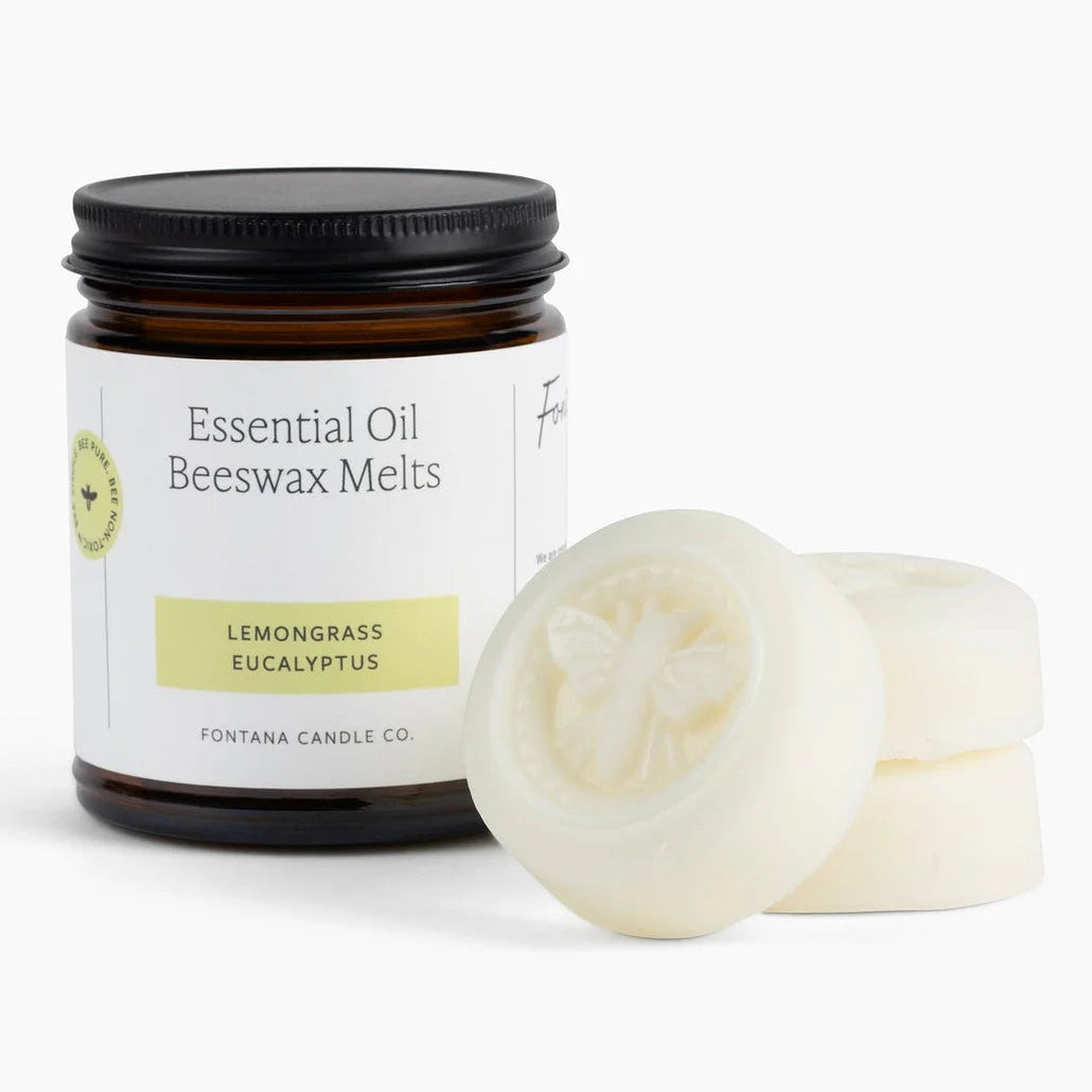 Jar of essential oil beeswax melts with two melts on a white background