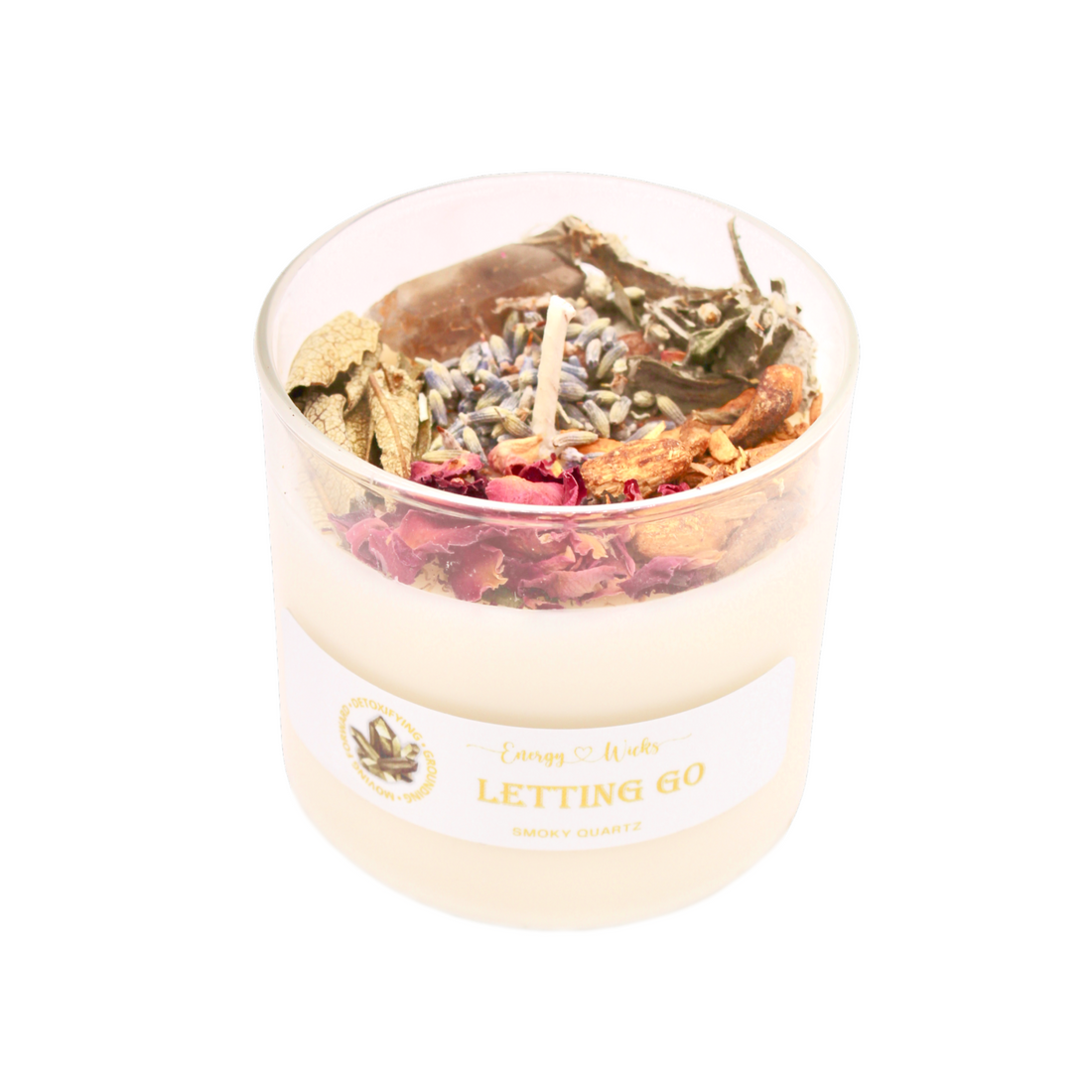 Candle in a glass jar with dried herbs and flowers, labeled &