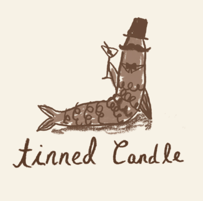 Logo of a bottle with a fish and a person inside, labeled 'tinned candle' on a beige background.