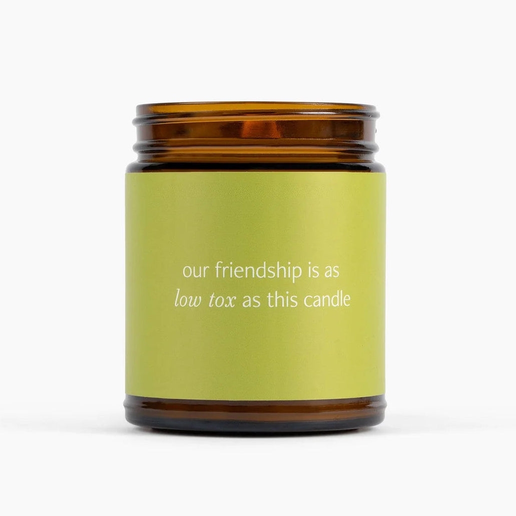 Candle with a green label and brown lid on a white background