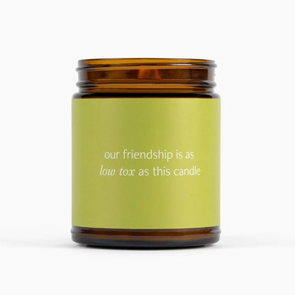 Candle with a green label and brown lid on a white background