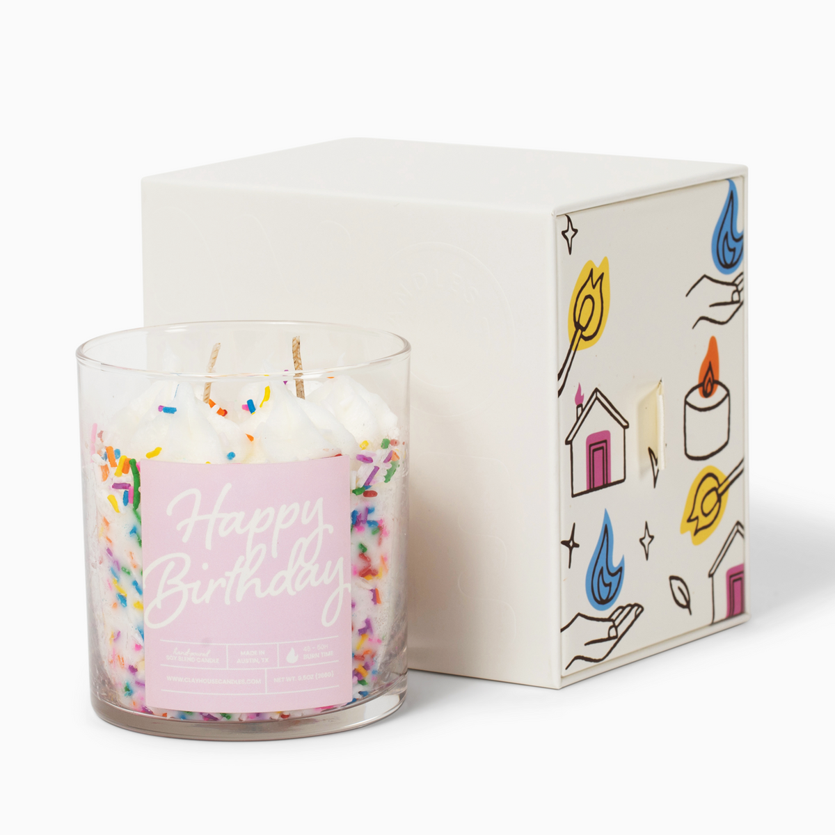 A clear glass jar candle filled with white wax and multicolored sprinkles, labeled &