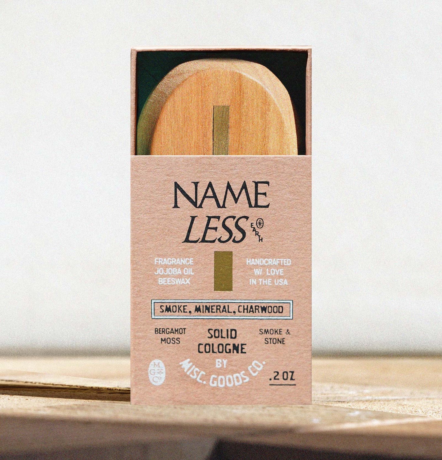 Solid cologne packaging with wooden applicator on a white background