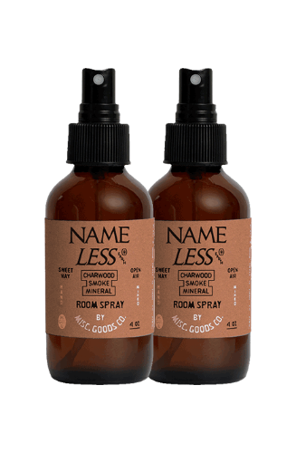 Two brown glass room spray bottles with black sprayers on a white background