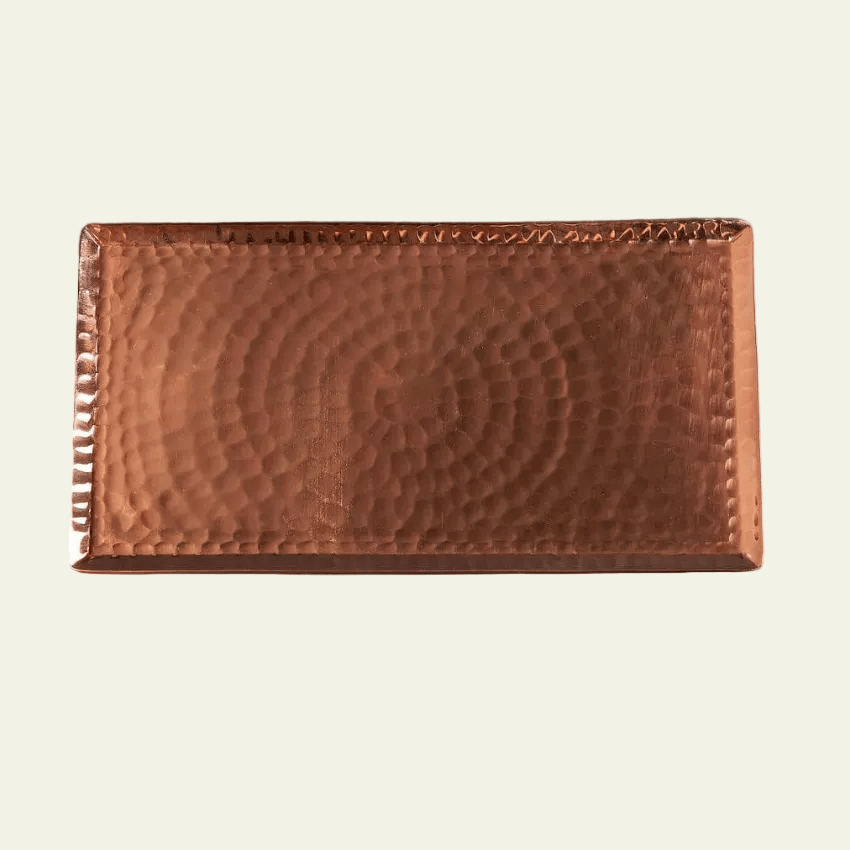 Copper tray with a textured surface on a black background