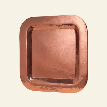 Copper tray with a textured surface on a light beige background