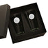 Two black glasses with white circular logos in a black box on a white background