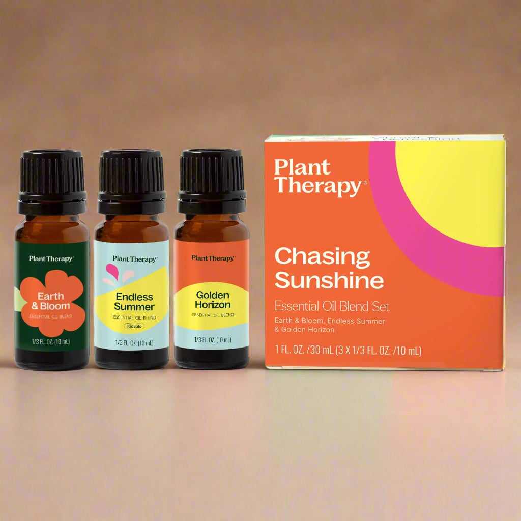 Three essential oil bottles with colorful labels and a box labeled &