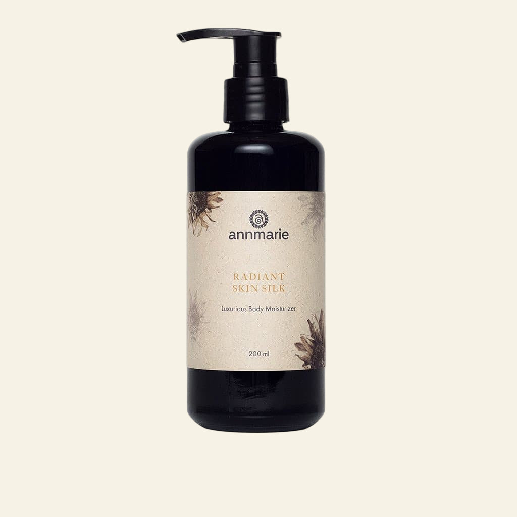 Black bottle of Annmarie Radiant Skin Silk body moisturizer on a white background