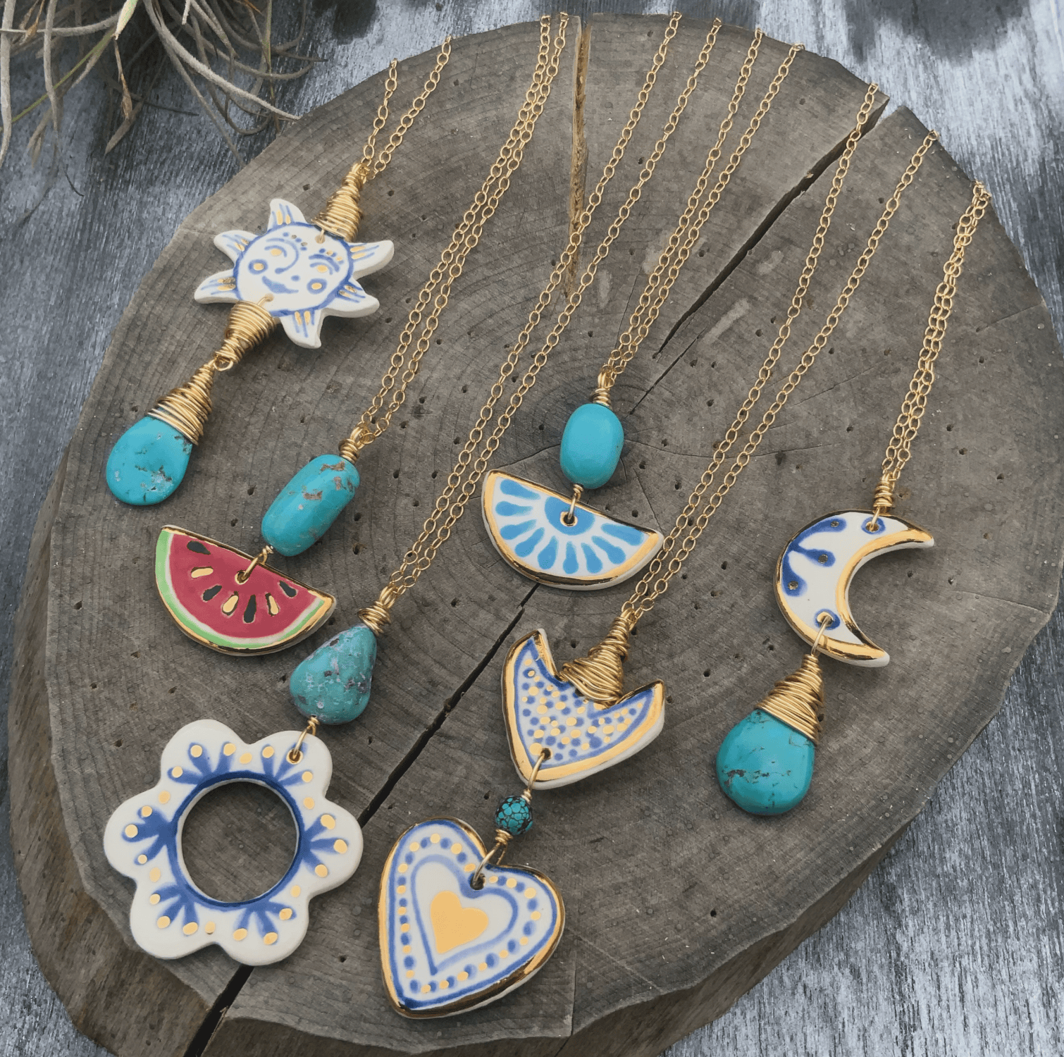 Colorful necklaces with ceramic pendants on a wooden surface