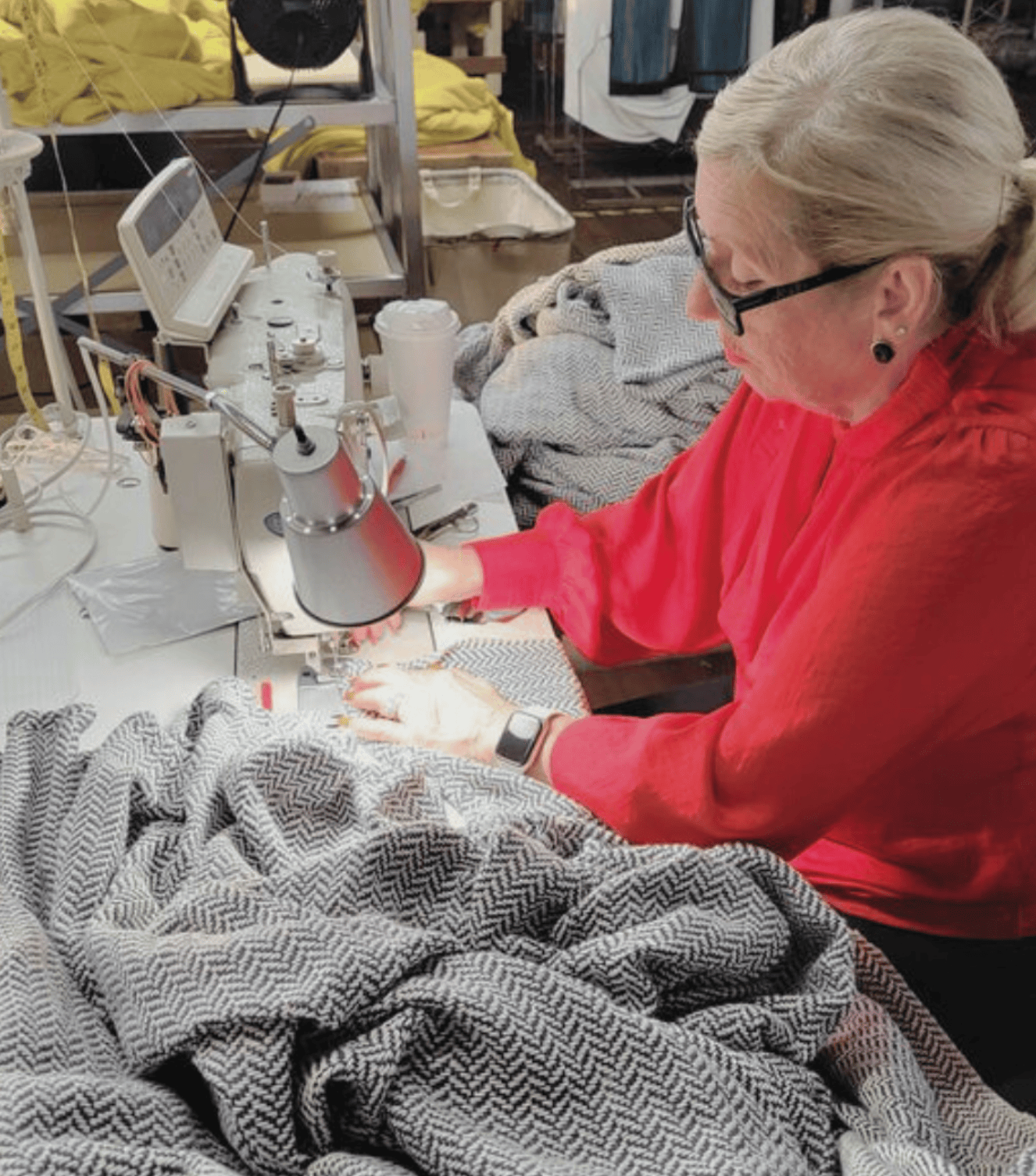 Woman on a sewing machine working on a herringbone blanket