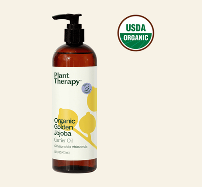 Bottle of Plant Therapy Organic Golden Jojoba Carrier Oil with USDA Organic label on a beige background