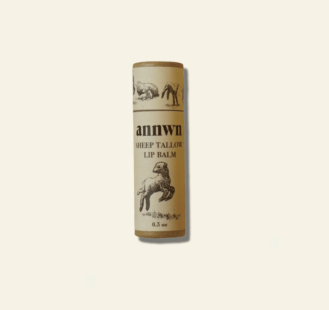 Sheep tallow lip balm tube with branding on a beige background