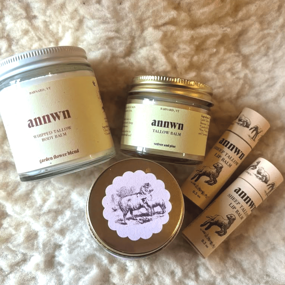 Collection of annwn tallow balm products on a soft, beige surface