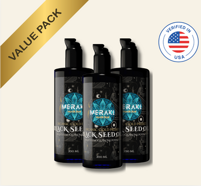 Three Meraki Black Seed Oil bottles with a gold &