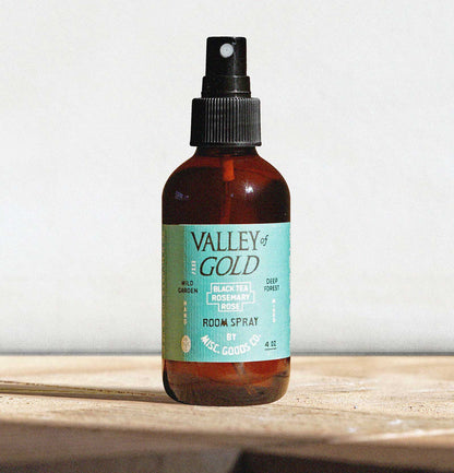 Brown spray bottle with a green label on a wooden surface