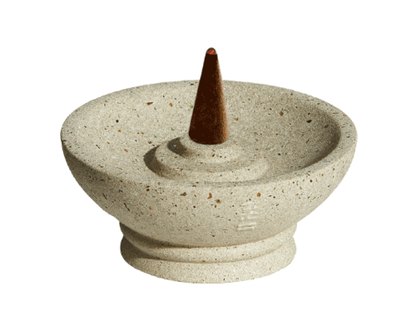 Decorative stone incense burner with a cone incense stick on a white background