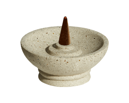 Decorative stone incense burner with a cone incense stick on a white background