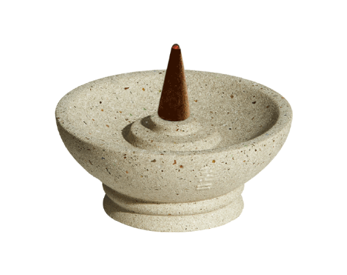 Decorative stone incense burner with a cone incense stick on a white background
