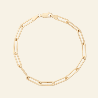 Gold chain bracelet on a light gray background