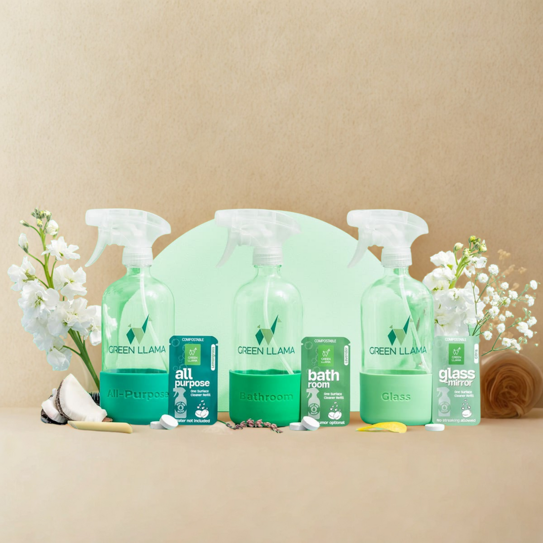 Set of Green Llama cleaning products on a beige background with flowers and cleaning tools.