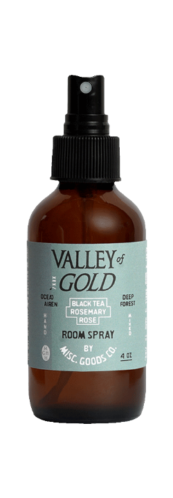 Brown room spray bottle with black cap labeled &