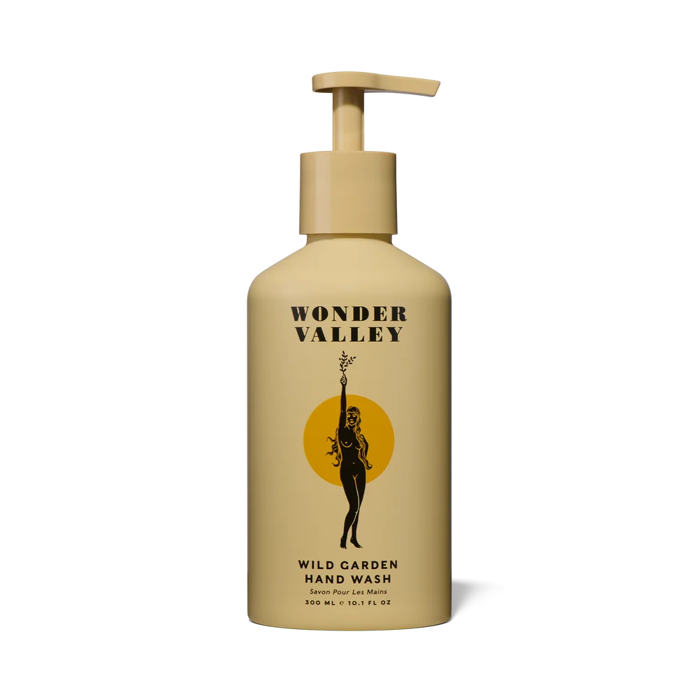 Wonder Valley Wild Garden Hand Wash in a beige pump bottle with a black and yellow label, shown on a clean white background.
