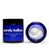 A dark blue jar of Purely Tallow Whipped Tallow Salt Scrub with a black lid, shown next to its open lid revealing white whipped cream inside, on a white background.