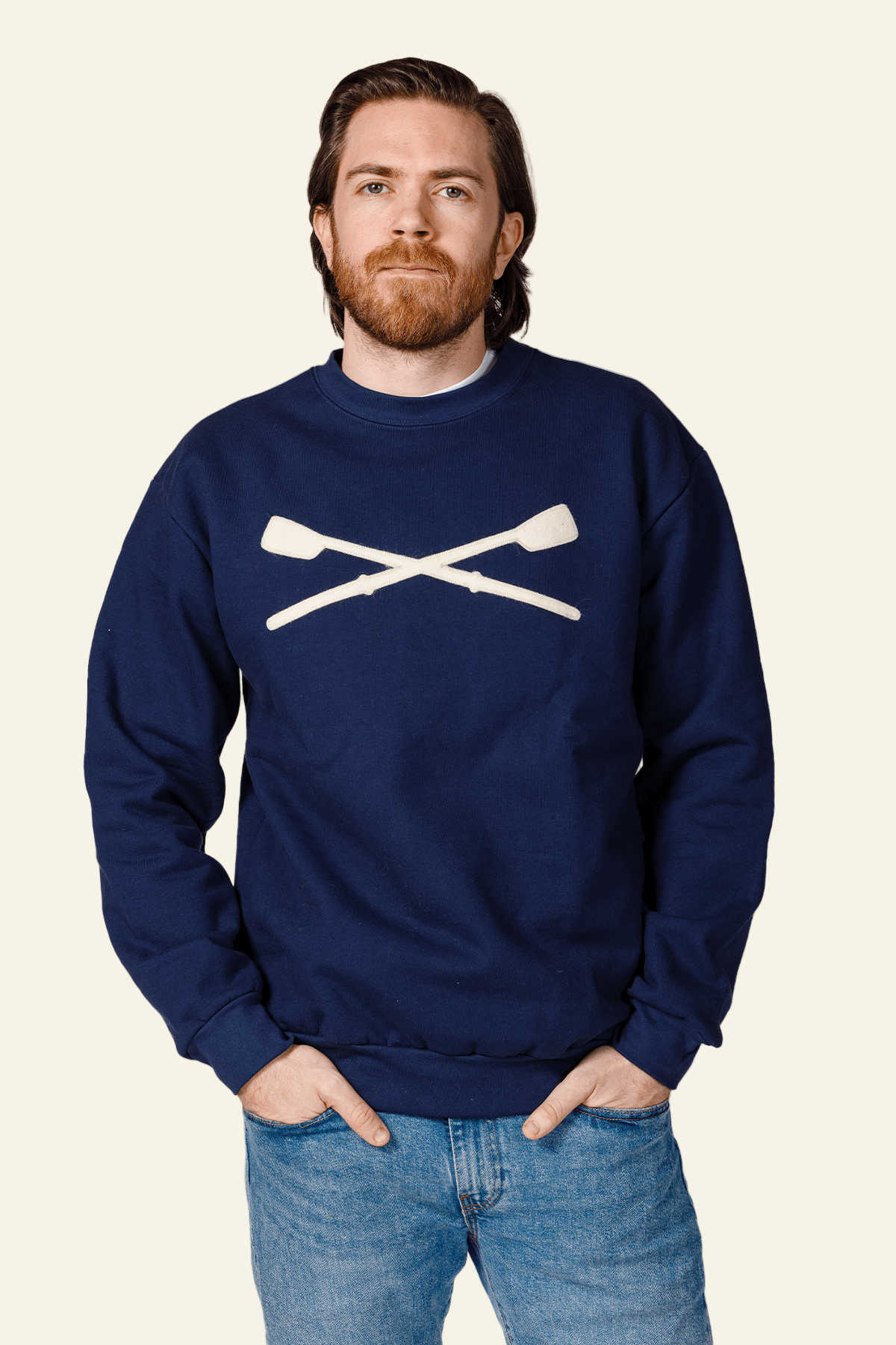 Man wearing a navy blue sweatshirt with a white graphic design on a white background