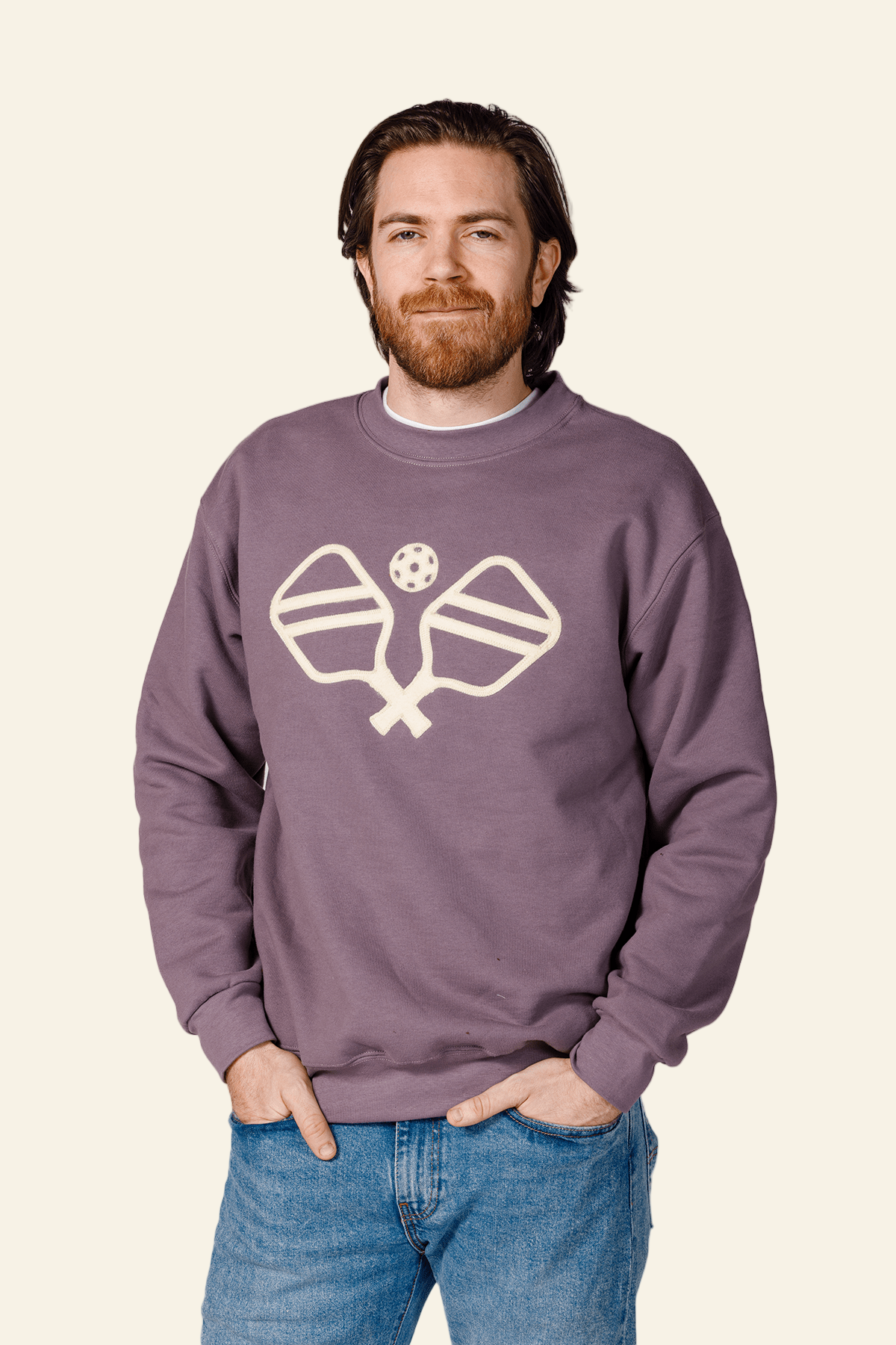 Man wearing a purple sweatshirt with a logo on a white background