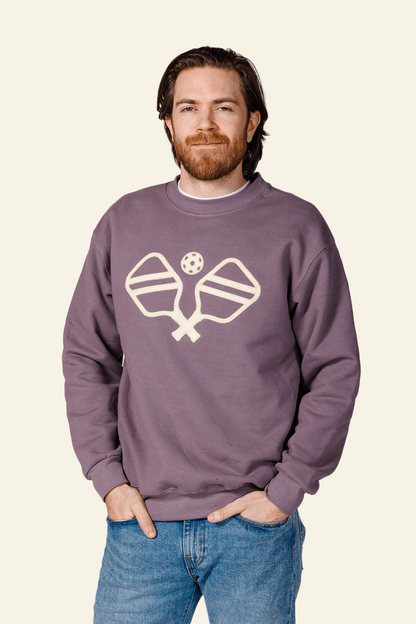 Man wearing a purple sweatshirt with a logo on a white background